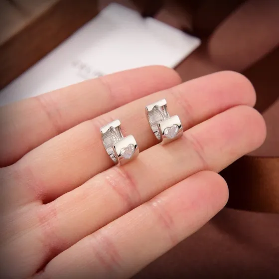 Celine Heart Crystal Huggie Hoop earrings silver-toned metal with clear heart-cut crystal accents 10mm outer diameter