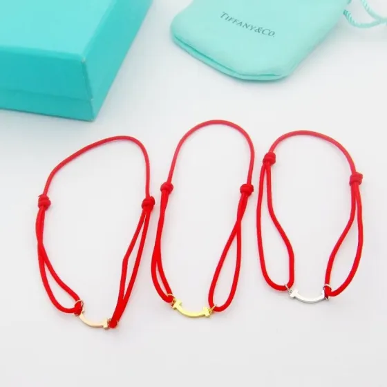Tiffany Co T Smile bracelet available in yellow gold rose gold silver metal finishes with red black or Tiffany blue cord adjustable sliding knot cord fits 15-20cm wrist