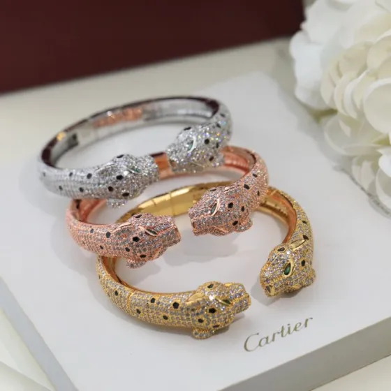 Cartier Panthere de Cartier bracelet Available in 18K white gold 18K rose gold 18K yellow gold fully paved with colorless diamonds black onyx spots green tsavorite garnet eyes 17cm