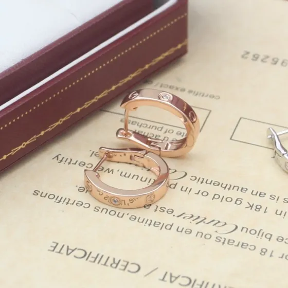 Cartier Love earrings Available in 18k rose gold 18k yellow gold and 18k white gold each set with small clear round diamonds 13mm outer hoop diameter