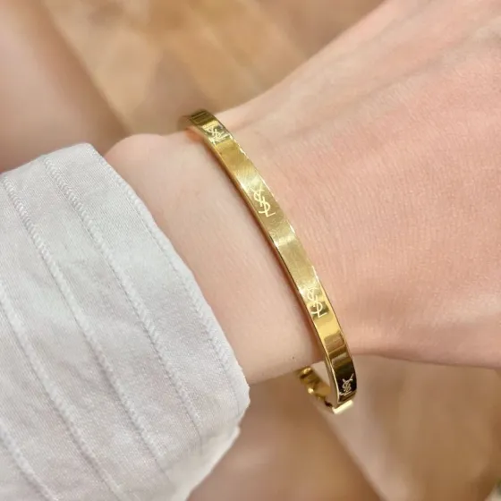 Saint Laurent Cassandre Logo Engraved Hinged Bangle bracelet 18K gold tone metal no accent stones 17cm inner circumference