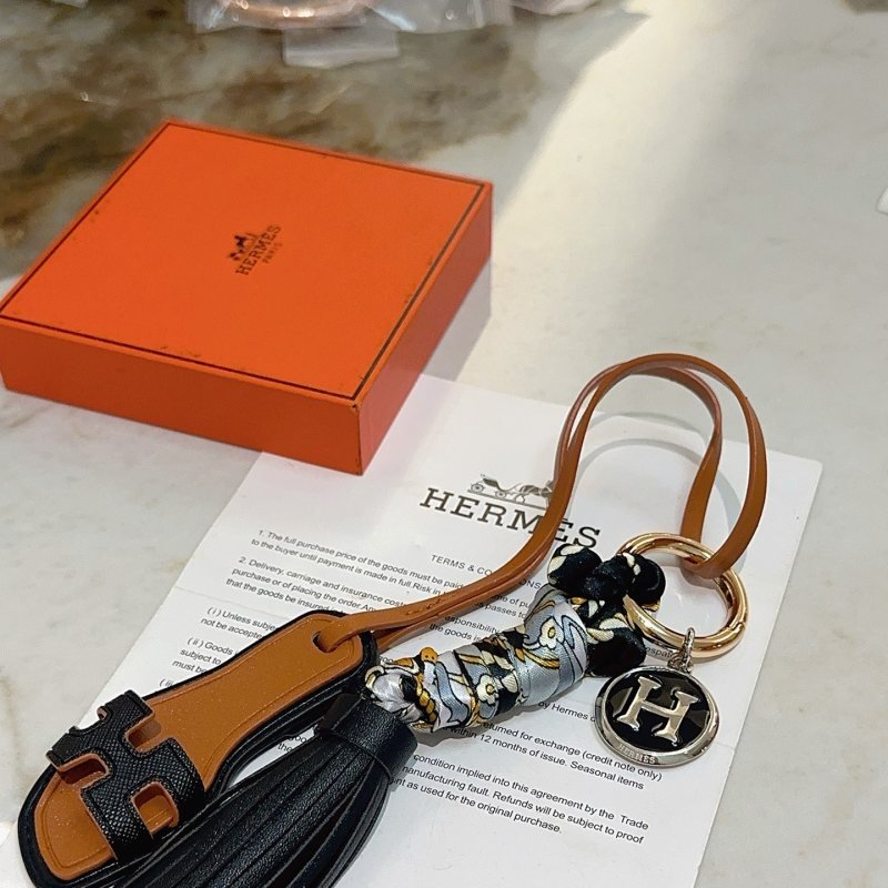 Hermes Oran Sandal Tassel H Logo Keychain Charm pendant Gold-tone metal black leather tan leather silver-tone metal with black enamel gray silk with gold and black floral print 12cm total length