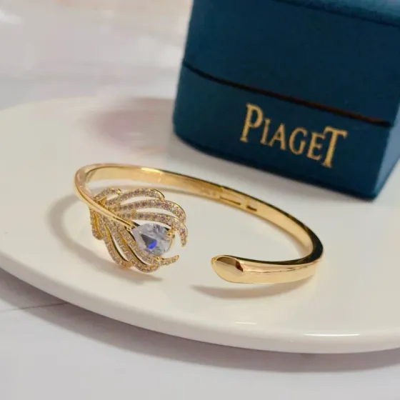 Piaget Feather Motif Open Cuff bracelet Yellow gold metal with clear faceted gemstones and pave-set clear accent stones 17cm inner circumference