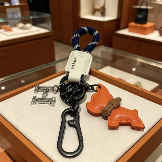 Hermes BRLATNY Puppy H Charm Keychain pendant Gunmetal black hardware orange leather puppy charm off-white leather tag navy blue with white woven rope brown leather collar detail 12cm total length