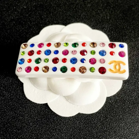 Chanel CC Logo Multicolor Crystal Resin Hair Barrette brooch White resin base with gold-tone interlocking CC logo multicolor faceted crystals in red blue green pink orange champagne and light pink hues 8cm length
