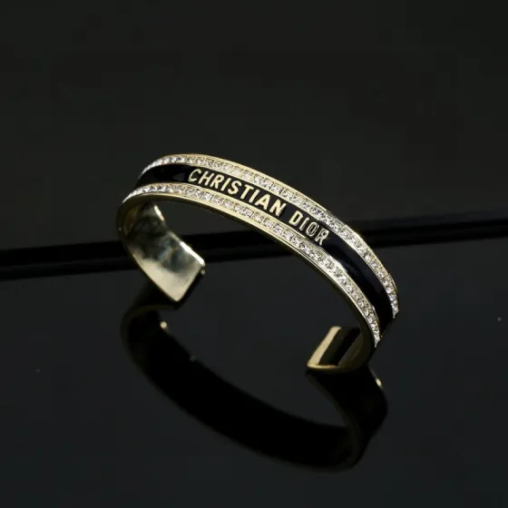 Dior Christian Dior Night Code Cuff bracelet Gold-tone metal with clear crystal accents available with black or white enamel inlay 17cm inner circumference