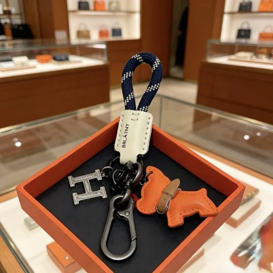 Hermes BRLATNY Puppy H Charm Keychain pendant Gunmetal hardware navy blue with white check woven strap off-white leather tag orange leather puppy charm with brown leather collar clear crystal accents on H charm 10cm total length