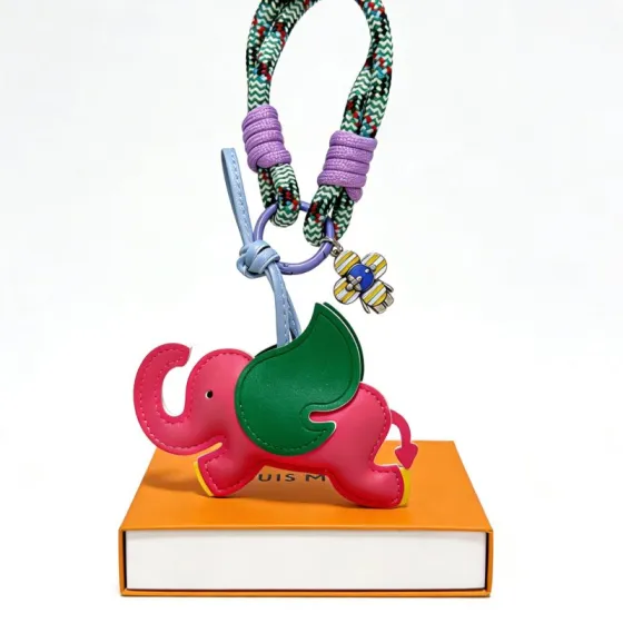 Louis Vuitton Anger Forest Elephant Keychain pendant Pink leather elephant with green ear yellow feet light blue leather strap purple cord wraps green-white chevron braided rope purple metal ring yellow-blue-silver enamel flower charm 12cm