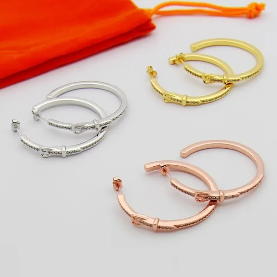 Hermes Buckle Hoop earrings Available in rose gold silver yellow gold metal tones with clear diamond-like accent stones 30mm diameter