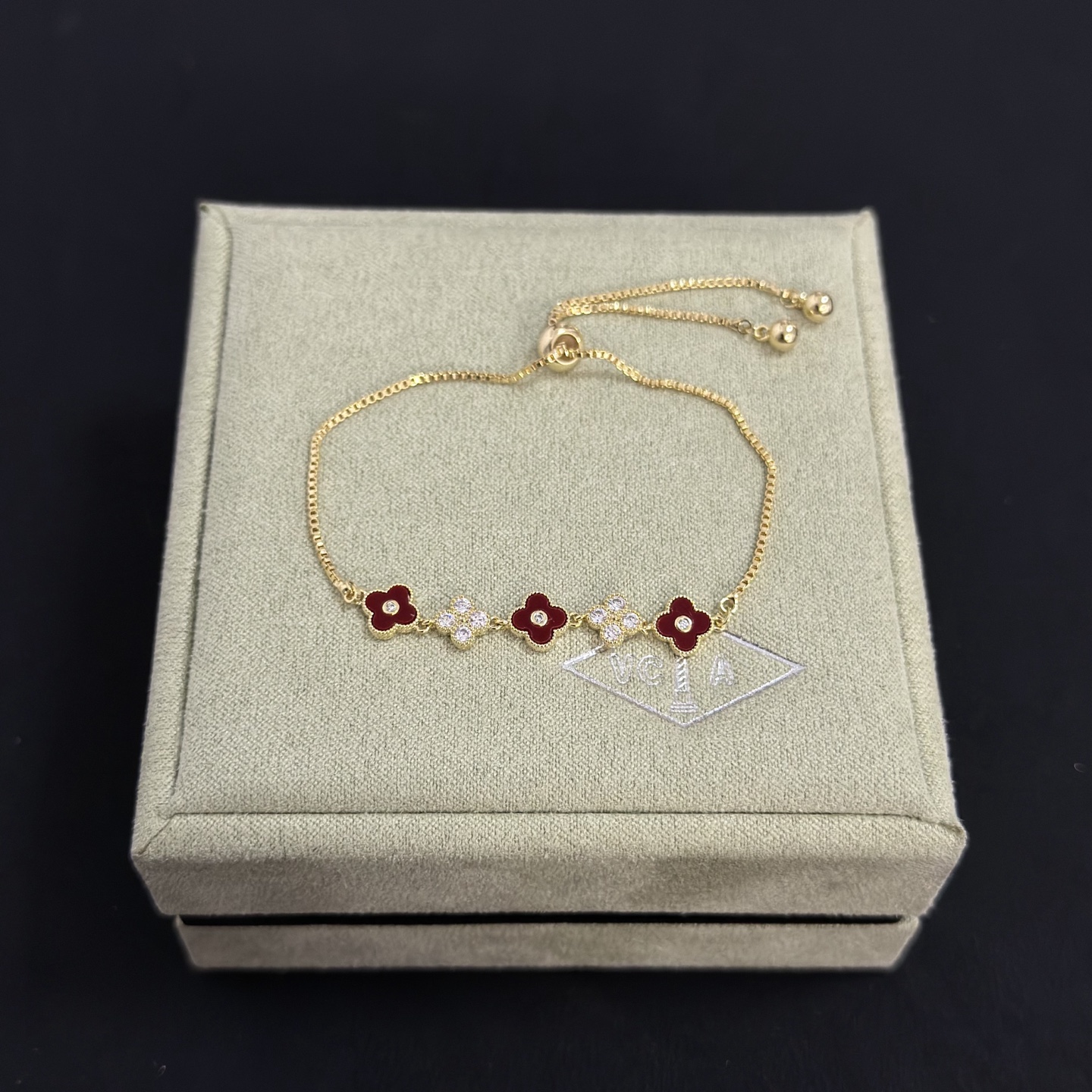 Van Cleef Arpels Alhambra bracelet yellow gold metal burgundy carnelian clover inlays clear diamond accents adjustable sliding chain maximum length 22cm