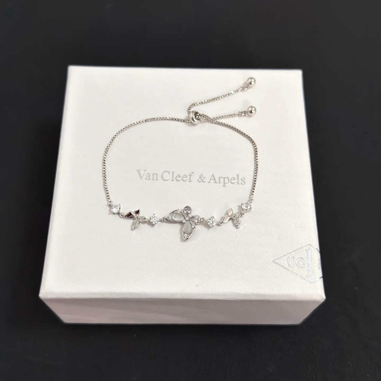 Bracciale regolabile Van Cleef Arpels con motivo a farfalla intarsiato con diamanti Metallo in oro bianco color argento con accenti di diamanti chiari e intarsi a farfalla in madreperla Chiusura scorrevole regolabile per polsi da 15-20 cm