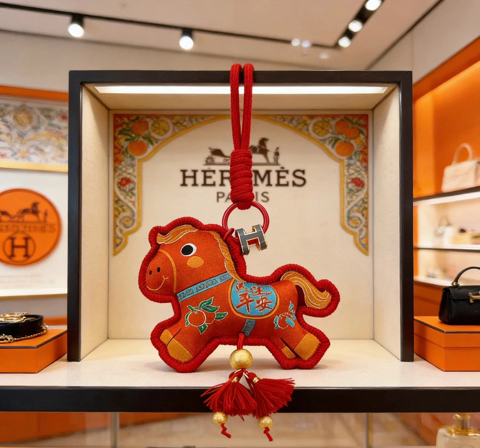 Ciondolo Hermes Rodeo Capodanno cinese a forma di cavallo Tessuto rosso con ricami dorati Dettagli accenti blu Hardware in metallo dorato Nappe rosse Ciondolo da 10 cm con cordino da 8 cm
