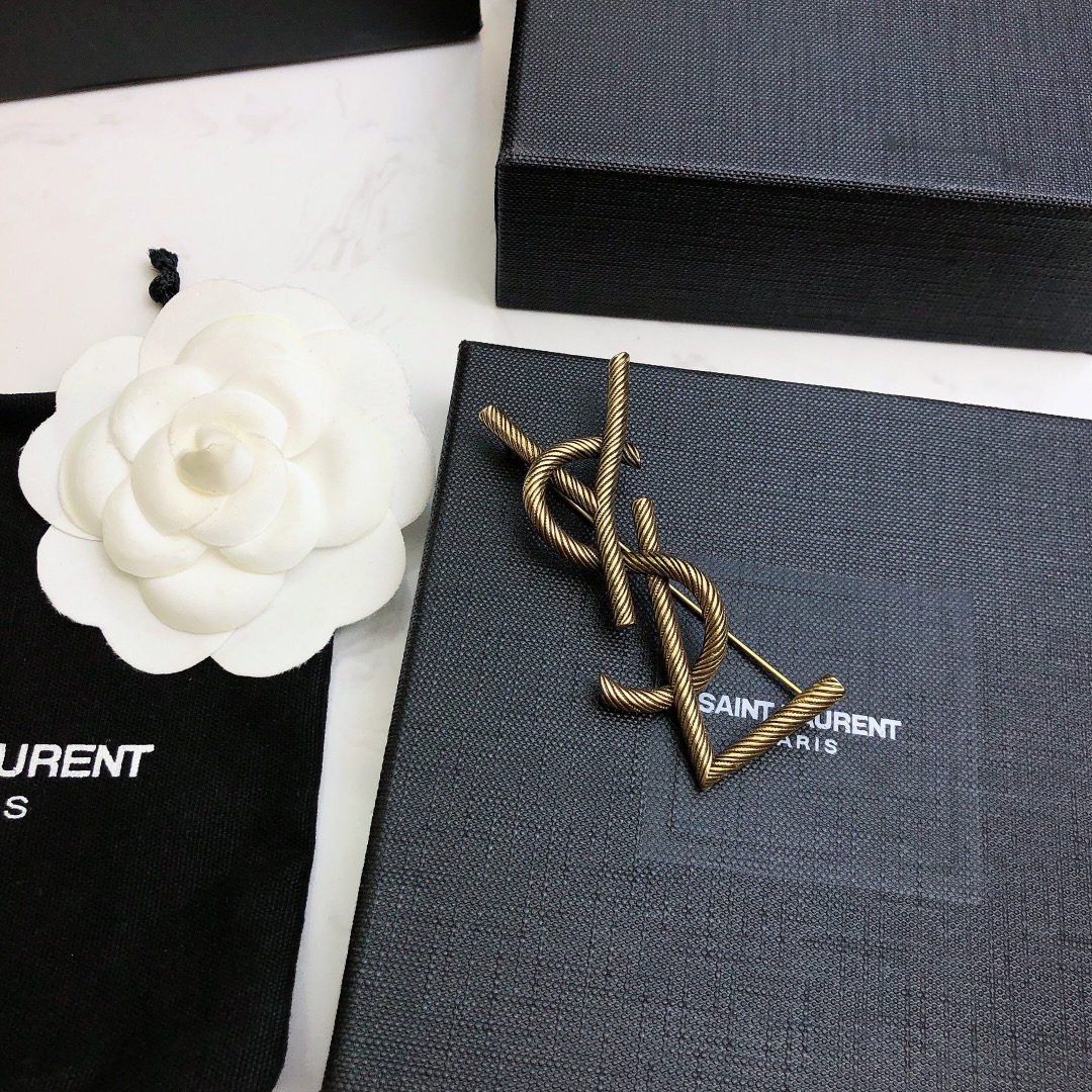 Saint Laurent Cassandre Twisted Monogram Brooch brooch antique brass gold metal no gemstones 4 5cm width