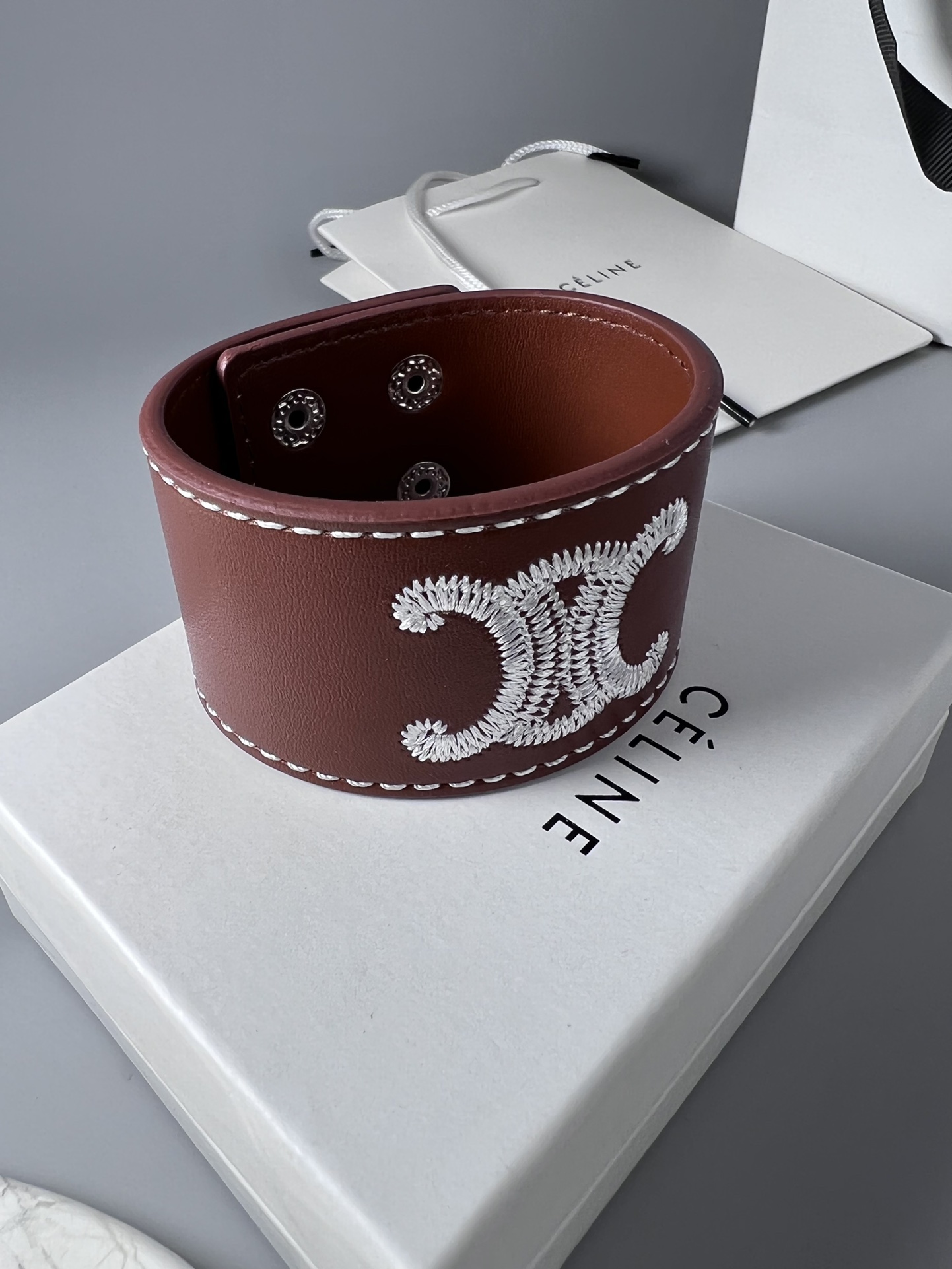 Celine Triomphe Embroidered Wide Leather Cuff bracelet burgundy brown smooth calfskin leather white contrast stitching silver-tone embroidered Triomphe logo silver-tone metal snap hardware adjustable snap closure 4cm width