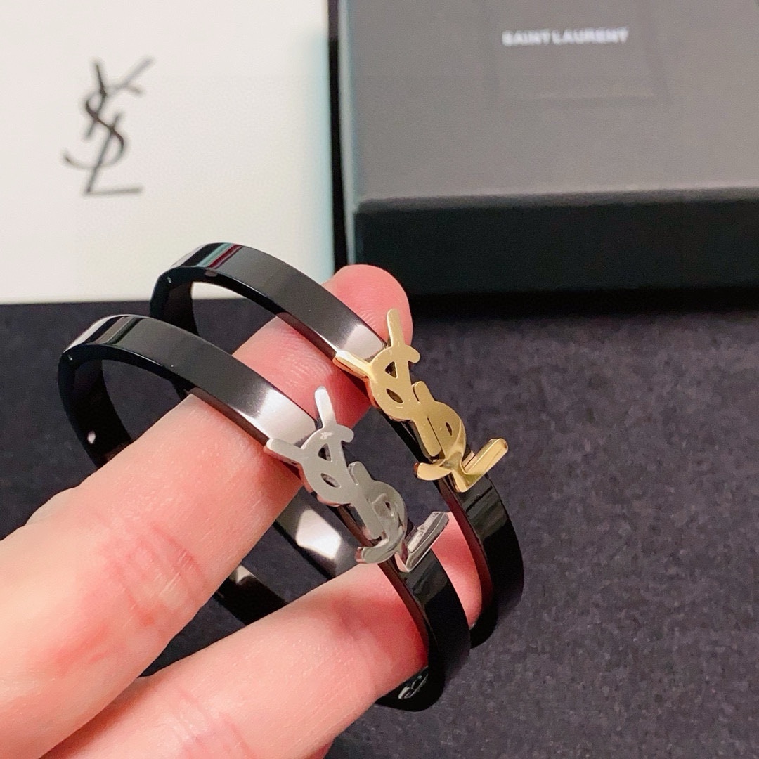 Saint Laurent Cassandre YSL Monogram Bangle bracelet Black polished metal band with gold-tone or silver-tone YSL logo hardware 17cm inner circumference