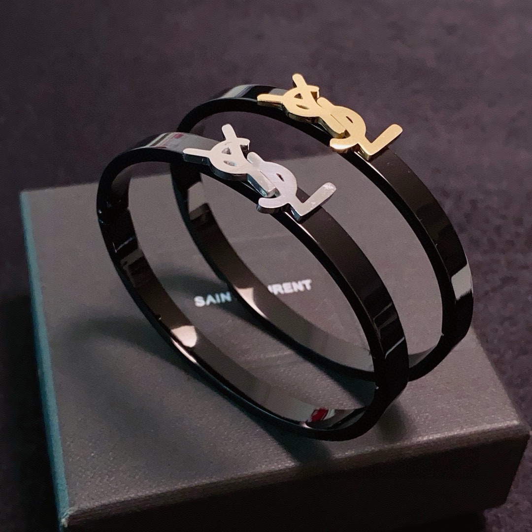 Saint Laurent Cassandre YSL Monogram Bangle bracelet Black polished metal band with gold-tone or silver-tone YSL logo hardware 17cm inner circumference