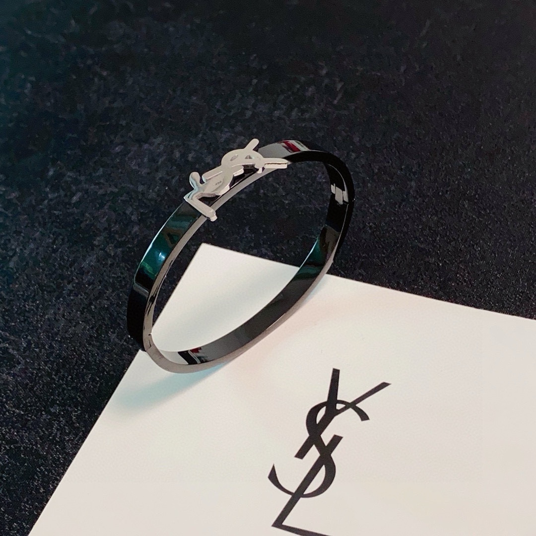 Saint Laurent Cassandre YSL Monogram Bangle bracelet Black polished metal band with gold-tone or silver-tone YSL logo hardware 17cm inner circumference