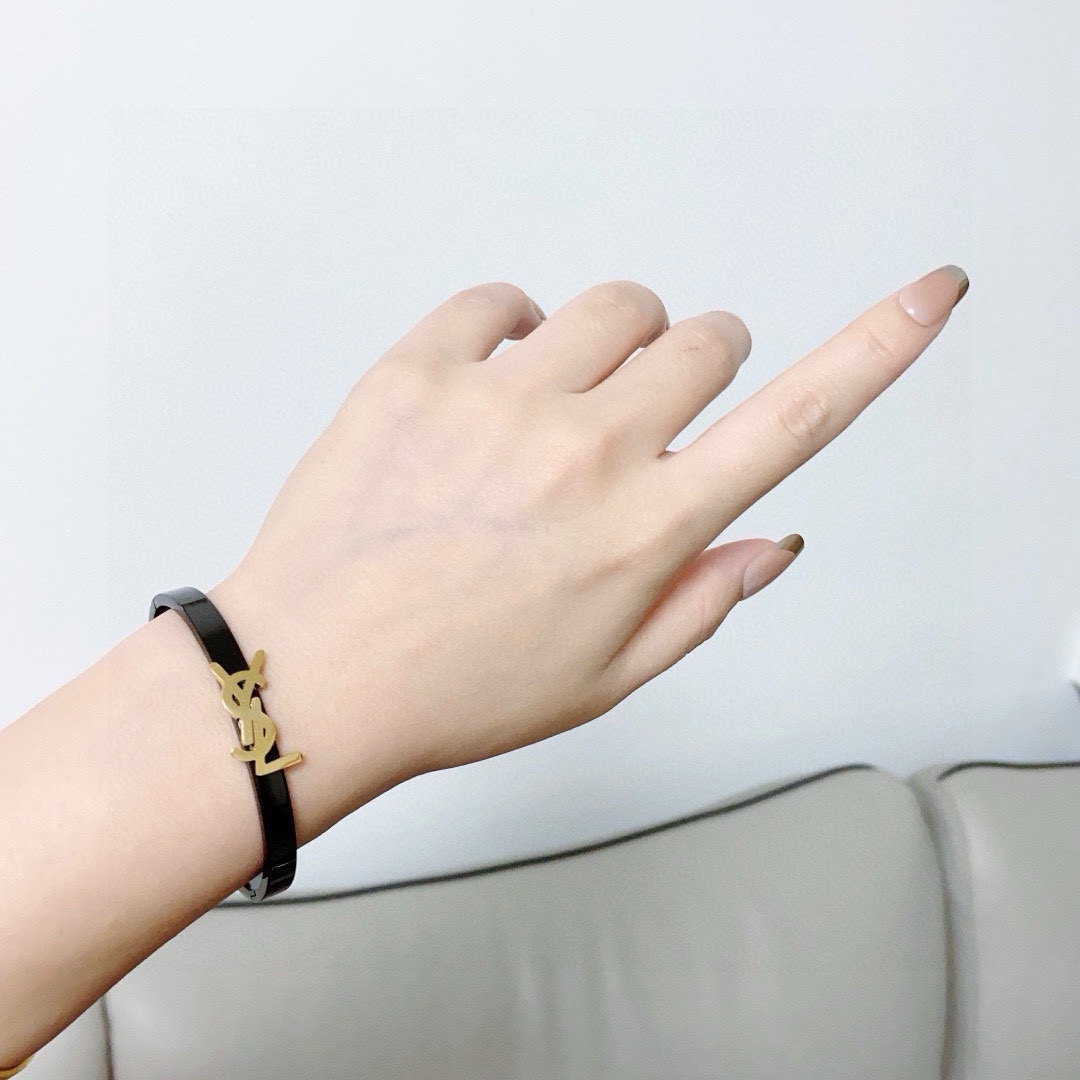 Saint Laurent Cassandre YSL Monogram Bangle bracelet Black polished metal band with gold-tone or silver-tone YSL logo hardware 17cm inner circumference