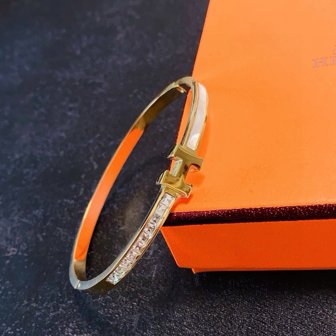 Bracciale Hermes Clic H MM in metallo color oro con cristalli trasparenti e smalto bianco