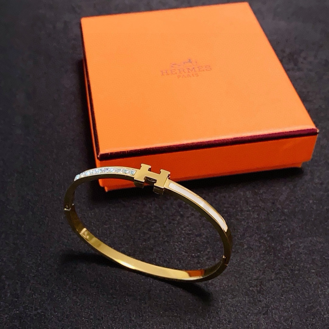 Bracciale Hermes Clic H MM in metallo color oro con cristalli trasparenti e smalto bianco