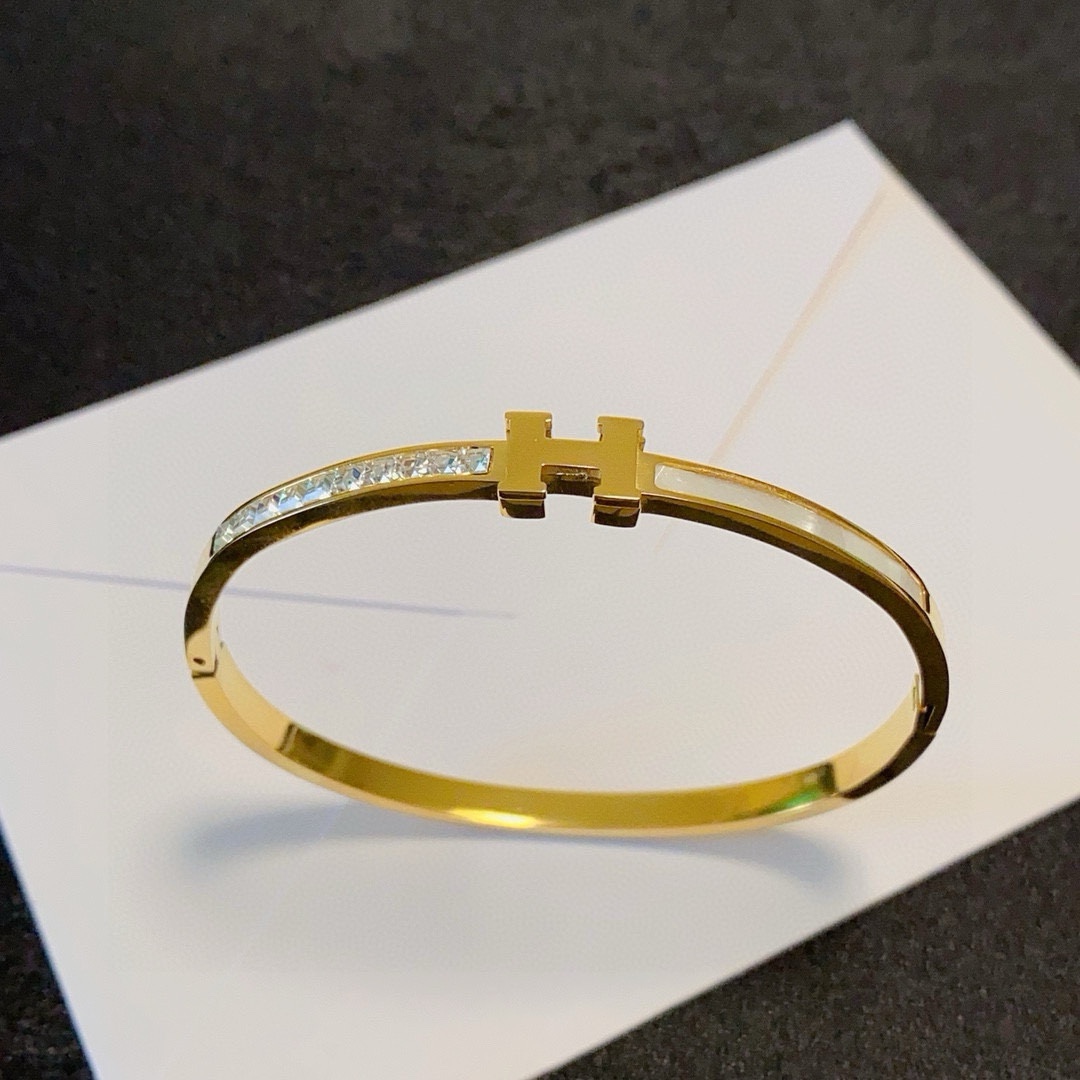 Bracciale Hermes Clic H MM in metallo color oro con cristalli trasparenti e smalto bianco