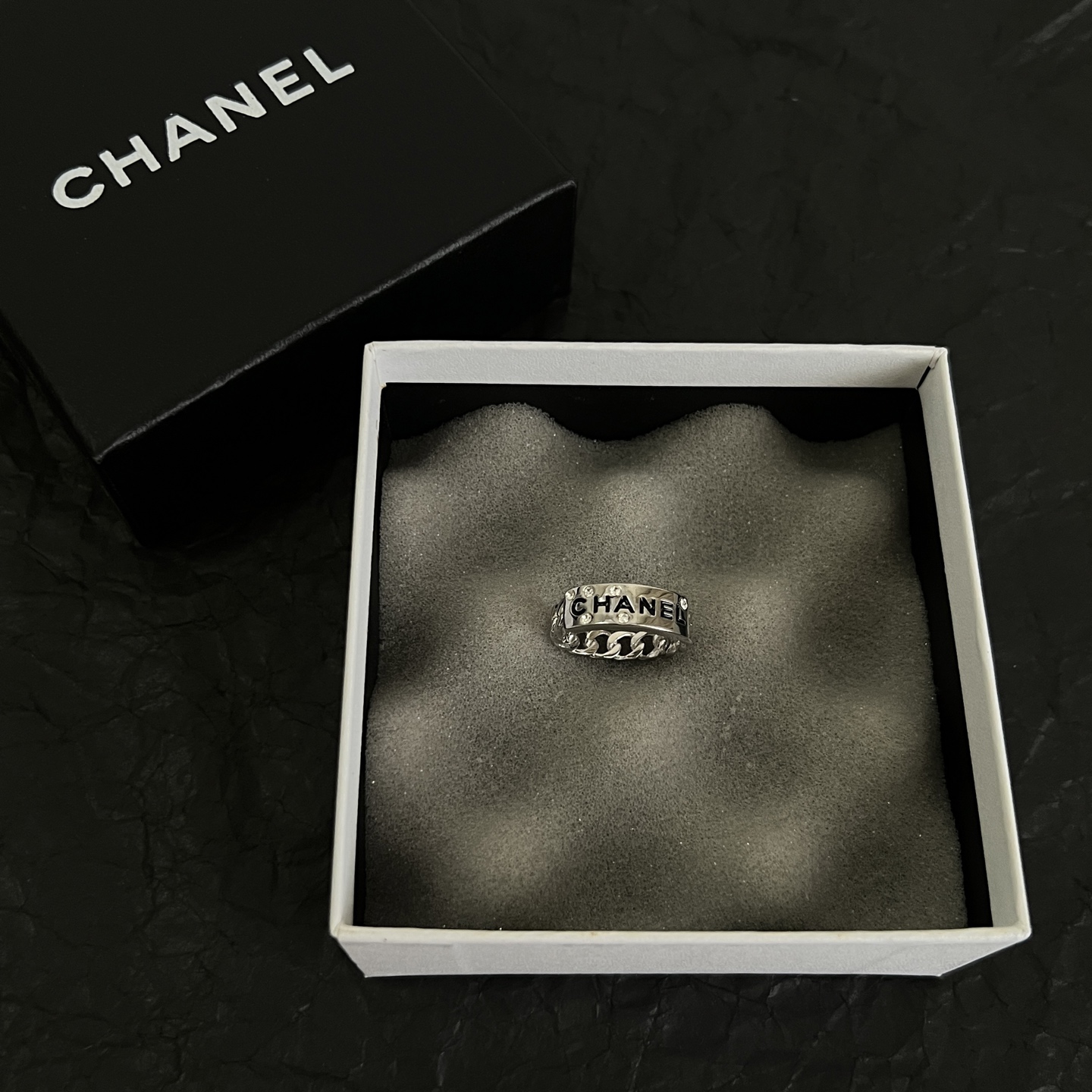 Chanel Logo Chain Crystal Ring ring Silver-toned metal with clear crystal accents and black enamel lettering US 7