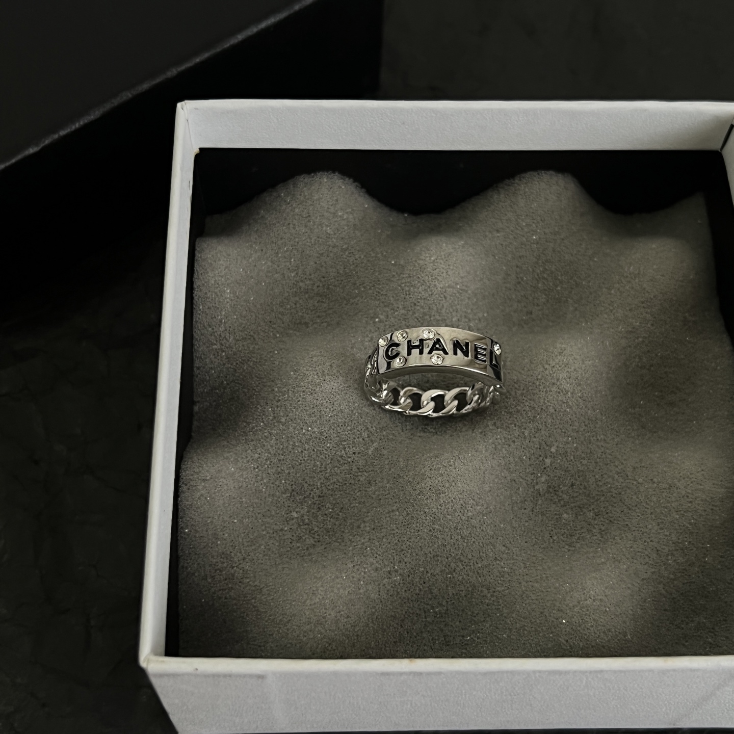 Chanel Logo Chain Crystal Ring ring Silver-toned metal with clear crystal accents and black enamel lettering US 7