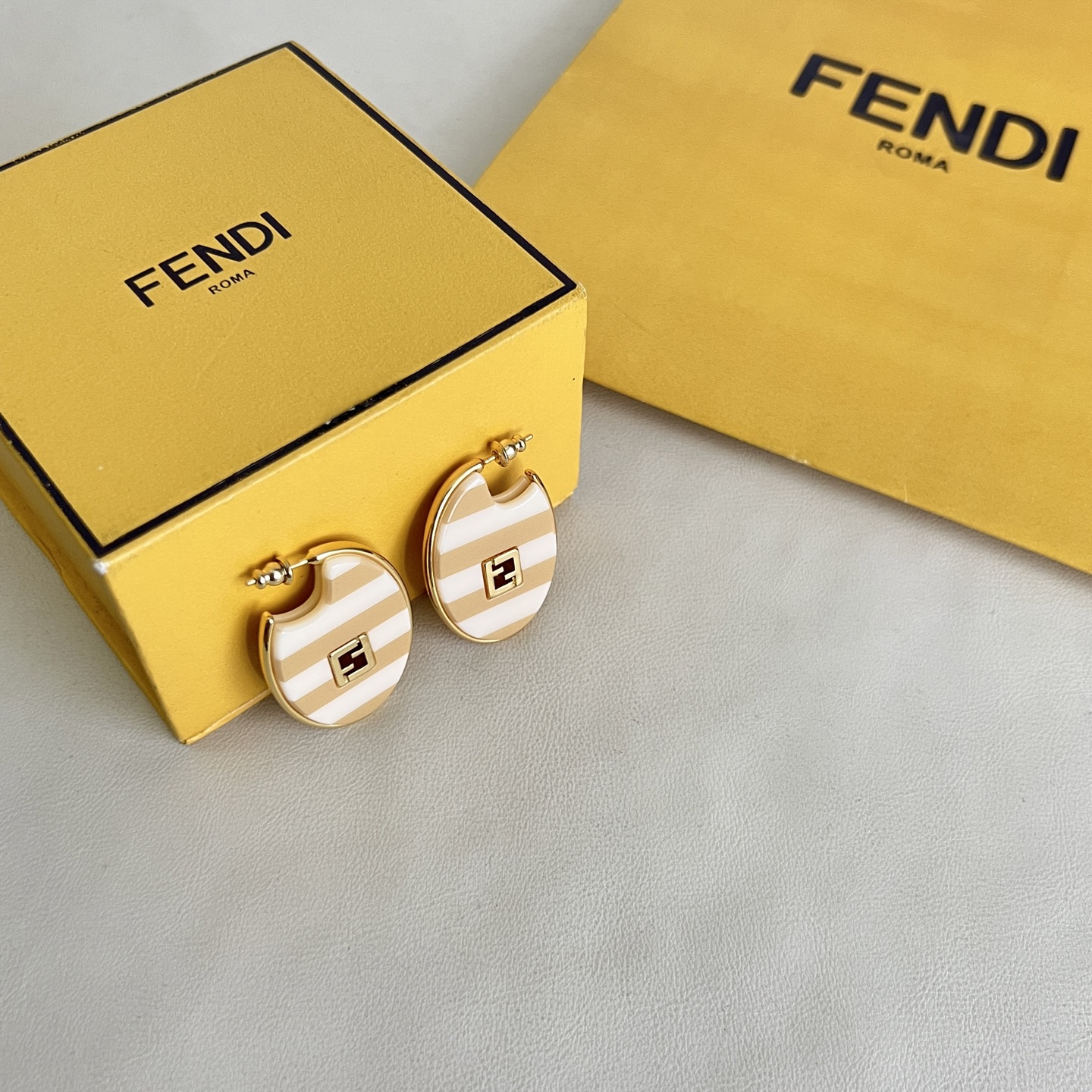 Fendi FF Logo Striped Hoop Earrings earrings Gold-tone metal with beige and white striped enamel gold FF logo accents One Size