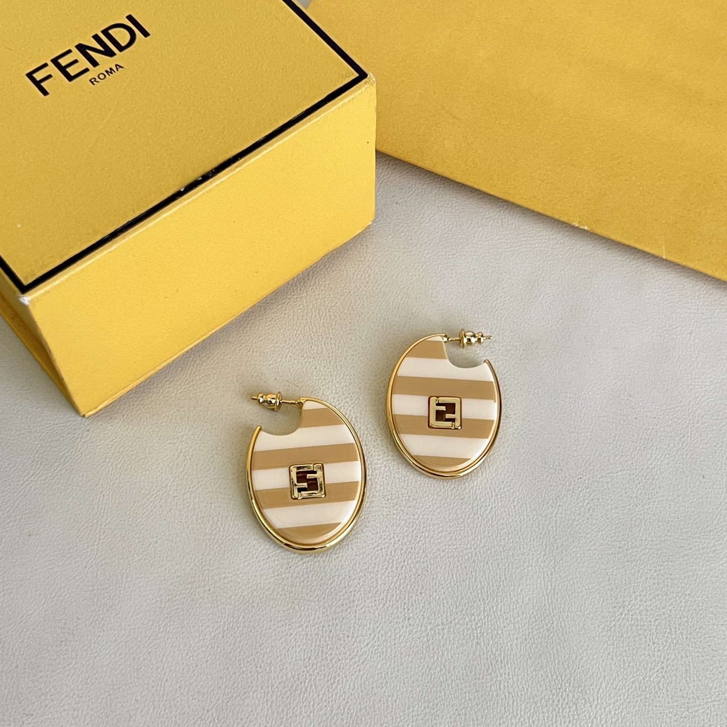 Fendi FF Logo Striped Hoop Earrings earrings Gold-tone metal with beige and white striped enamel gold FF logo accents One Size