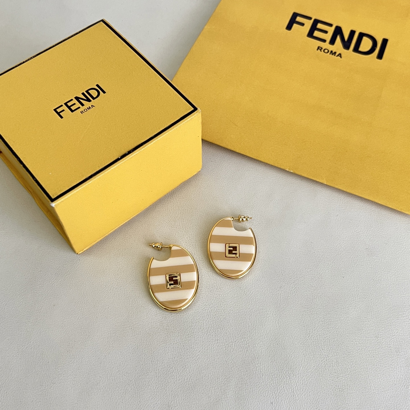 Fendi FF Logo Striped Hoop Earrings earrings Gold-tone metal with beige and white striped enamel gold FF logo accents One Size