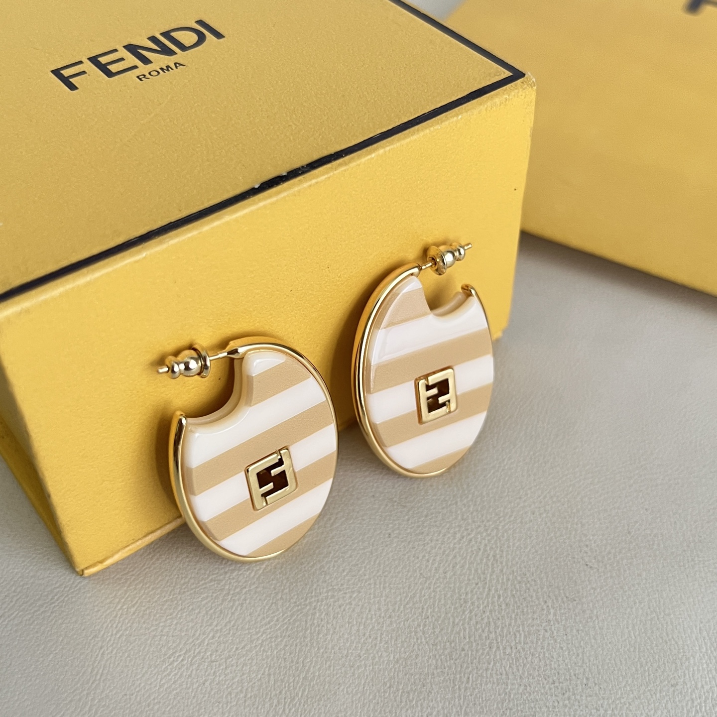 Fendi FF Logo Striped Hoop Earrings earrings Gold-tone metal with beige and white striped enamel gold FF logo accents One Size