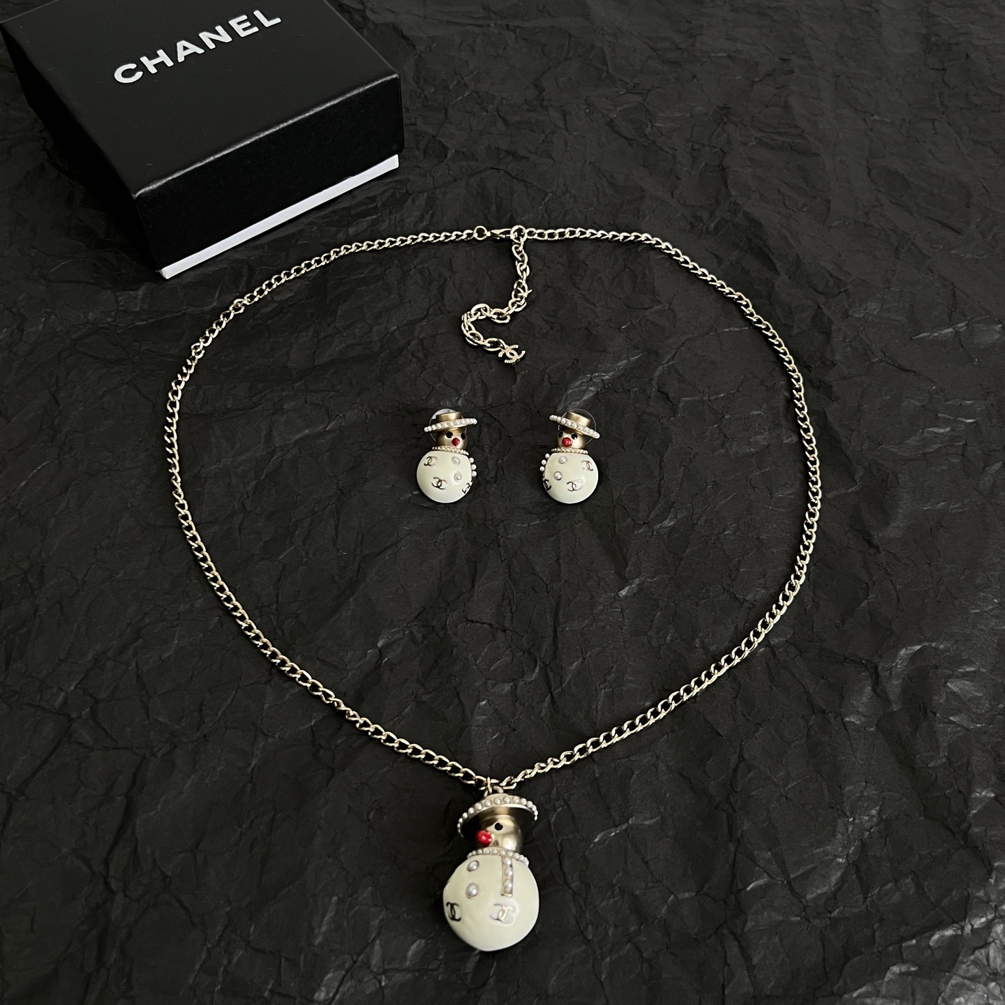 Chanel Snowman CC Holiday Collection earrings Light gold-tone metal cream white enamel clear crystal accents red enamel nose faux pearl trim One Size stud earrings no visible length marking
