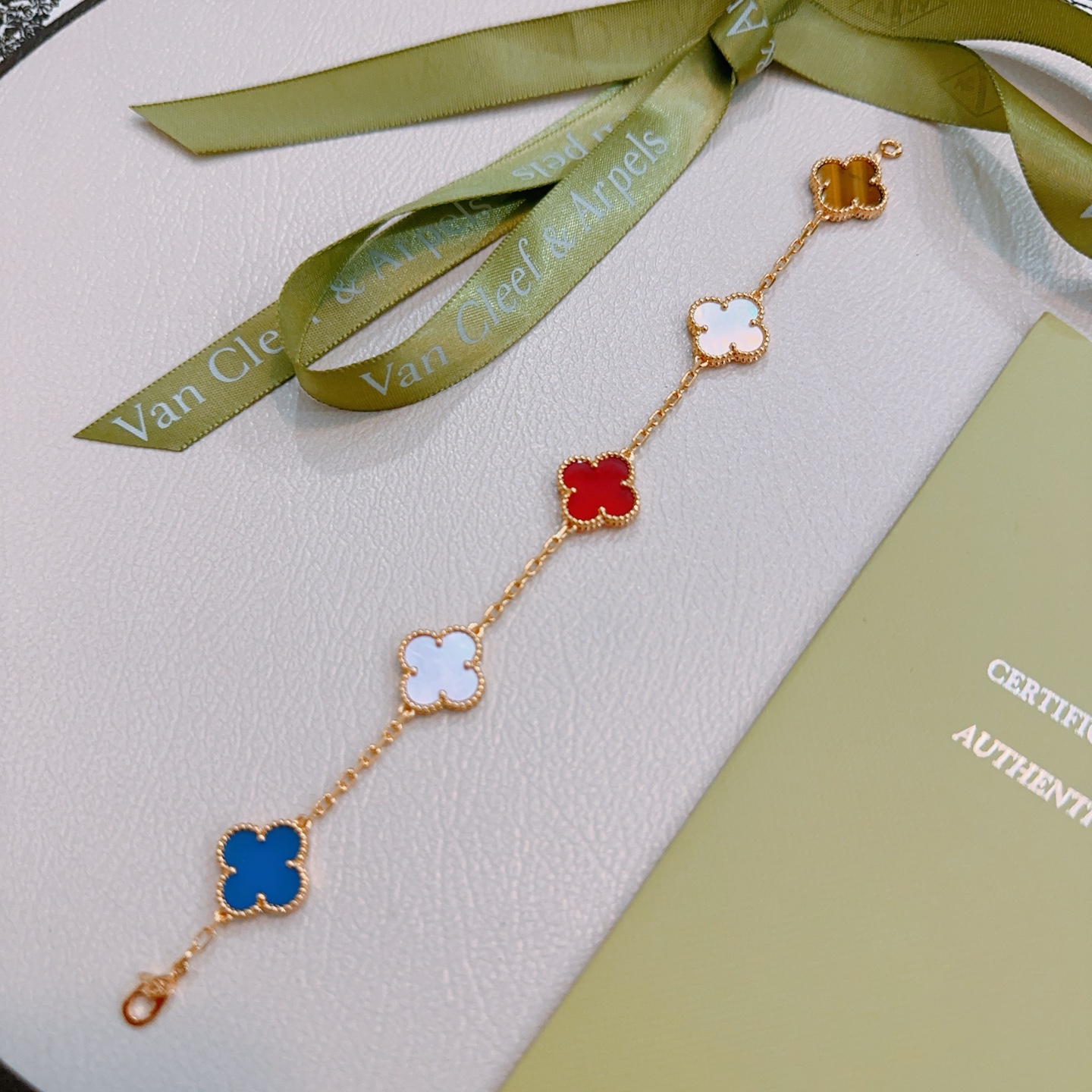 Van Cleef Arpels Bracelet Alhambra Métal doré avec nacre rose cornaline rouge nacre blanche agate bleue et motifs trèfle oeil de tigre marron 17cm