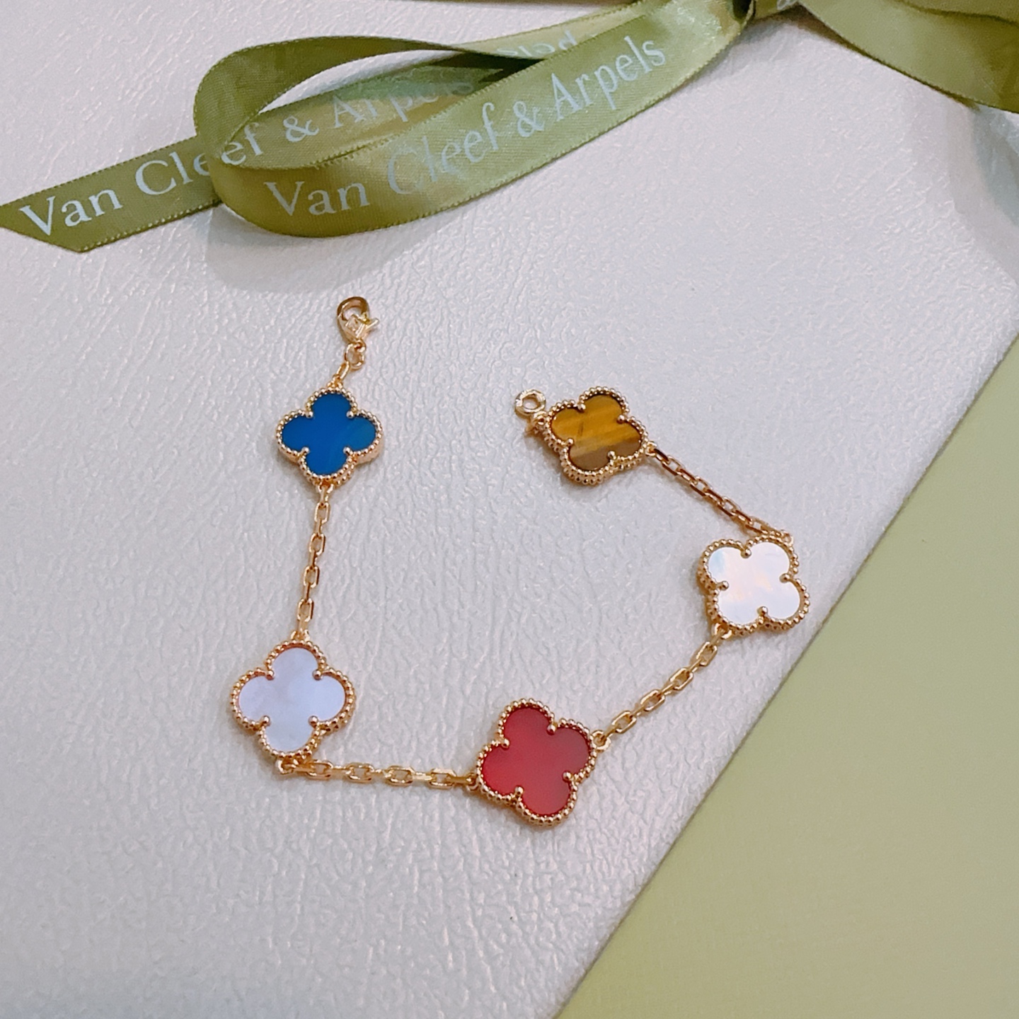 Van Cleef Arpels Bracelet Alhambra Métal doré avec nacre rose cornaline rouge nacre blanche agate bleue et motifs trèfle oeil de tigre marron 17cm