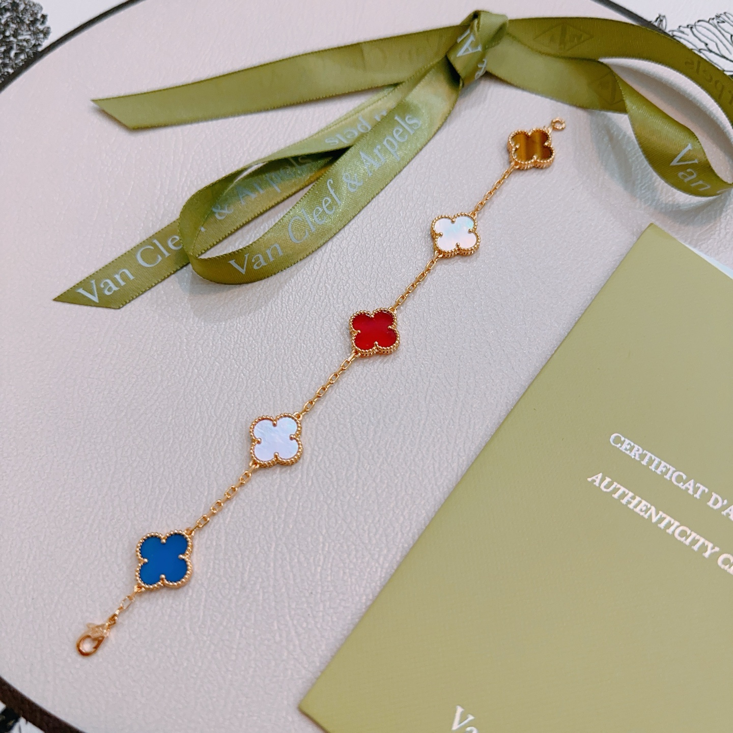 Van Cleef Arpels Bracelet Alhambra Métal doré avec nacre rose cornaline rouge nacre blanche agate bleue et motifs trèfle oeil de tigre marron 17cm