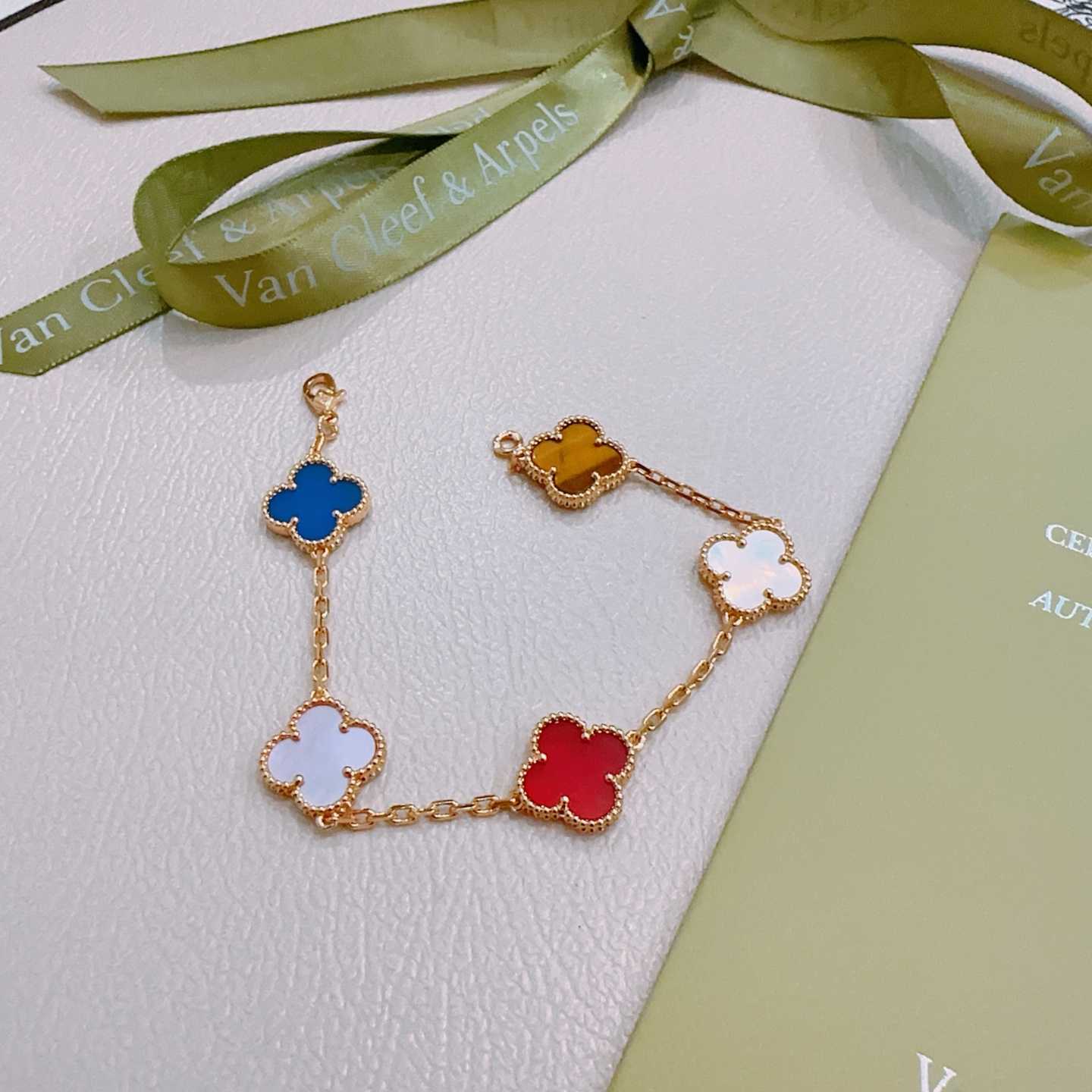 Van Cleef Arpels Bracelet Alhambra Métal doré avec nacre rose cornaline rouge nacre blanche agate bleue et motifs trèfle oeil de tigre marron 17cm