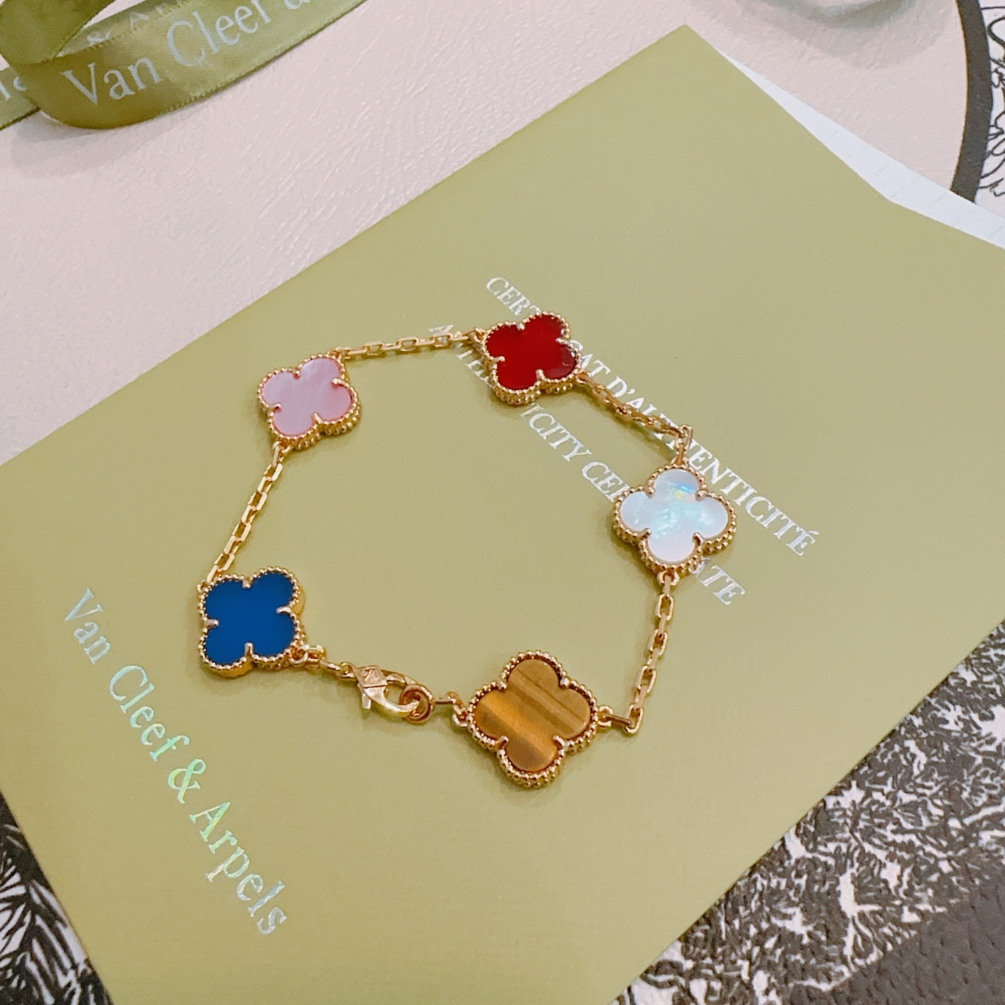 Van Cleef Arpels Bracelet Alhambra Métal doré avec nacre rose cornaline rouge nacre blanche agate bleue et motifs trèfle oeil de tigre marron 17cm