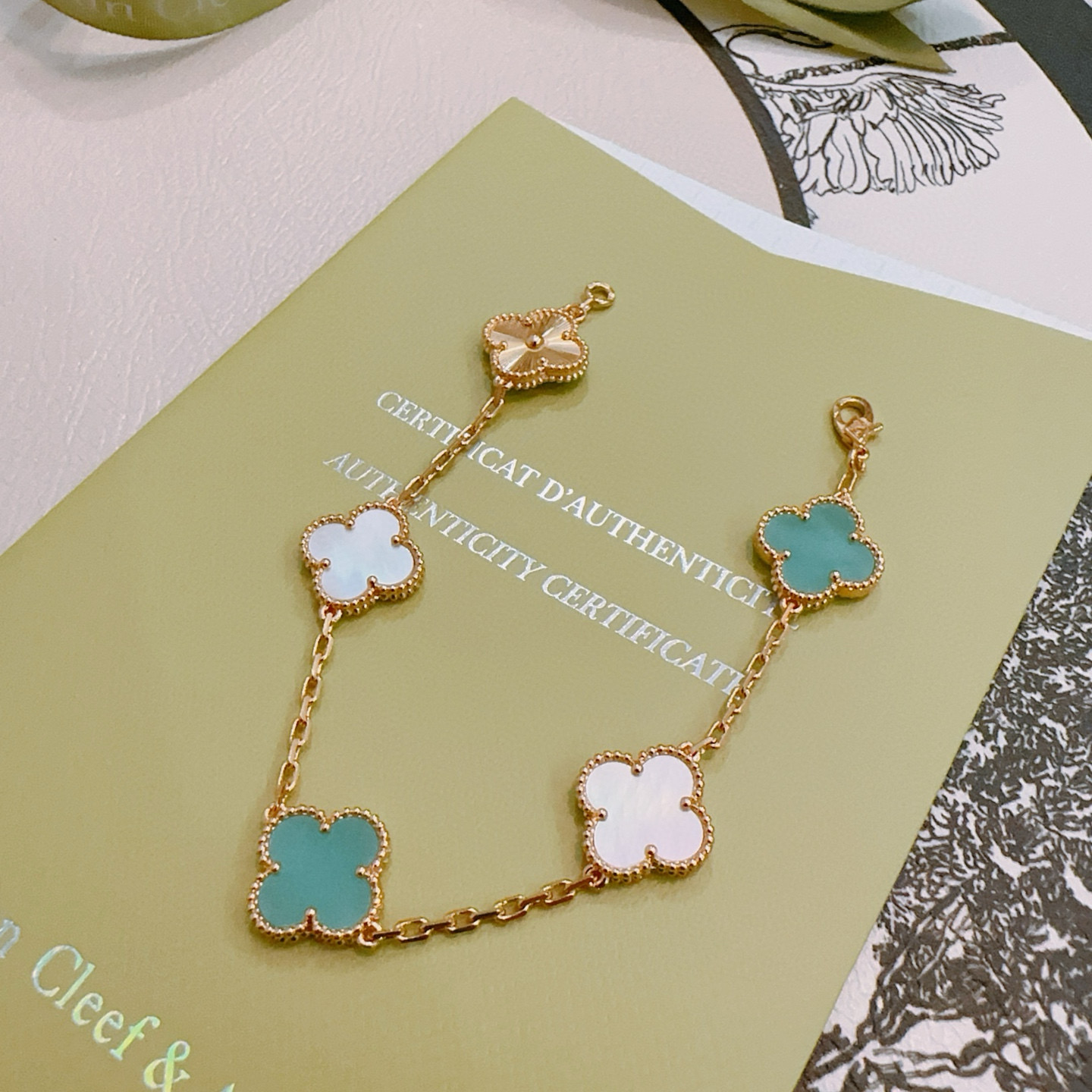 Bracelet Van Cleef Arpels Alhambra Métal doré rose avec motifs de nacre blanche bleu turquoise et guilloché or rose trèfle à quatre feuilles 18cm