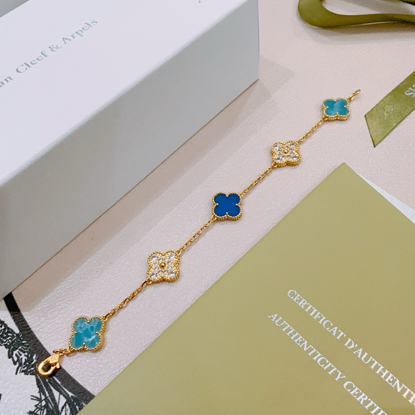 Bracelet Van Cleef Arpels Alhambra Métal doré avec motifs trèfle à quatre feuilles bleu turquoise bleu royal et diamants clairs rehaussés de diamants 18cm
