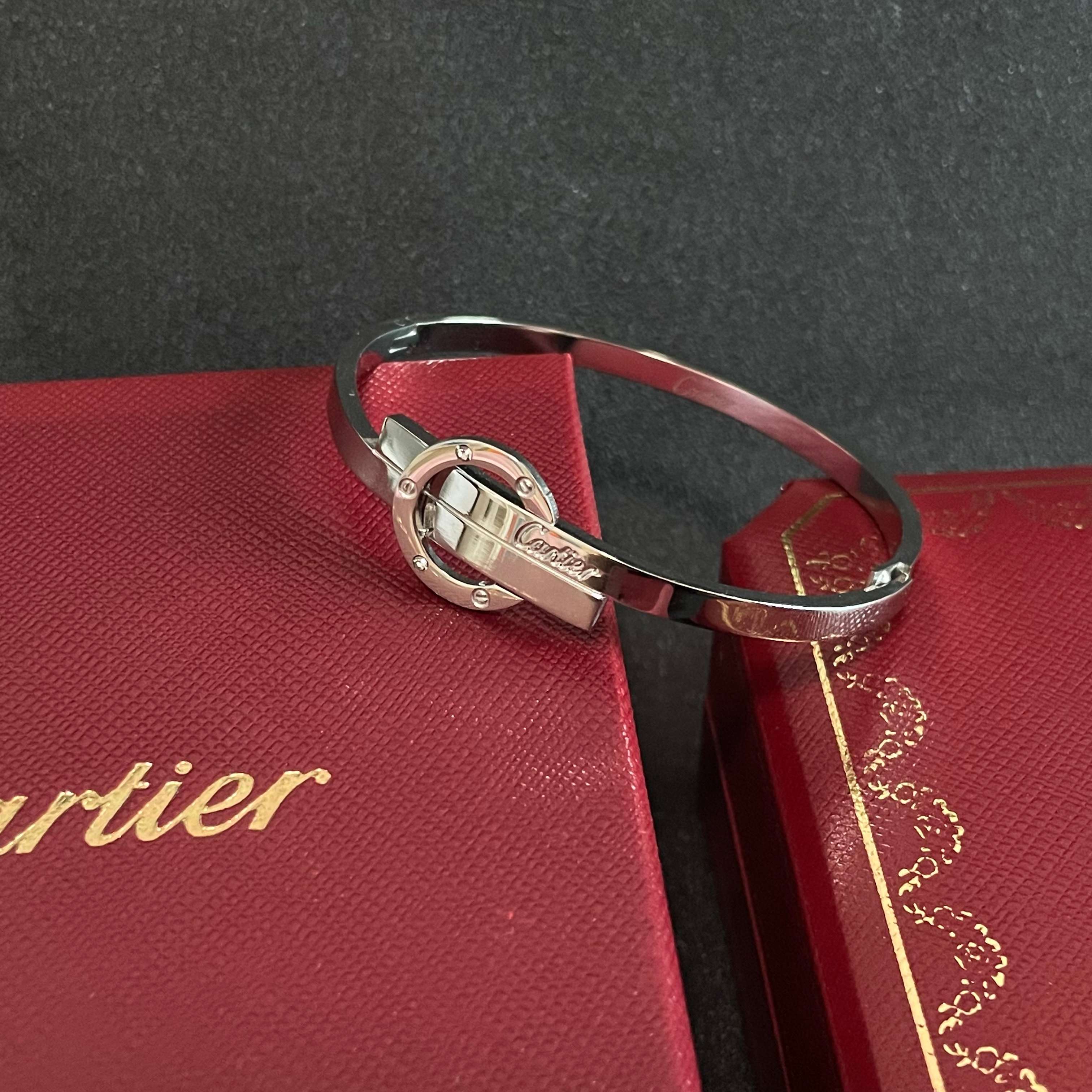Cartier Love Interlocking Clasp Bangle bracelet Silver-toned metal with clear diamond accents 17