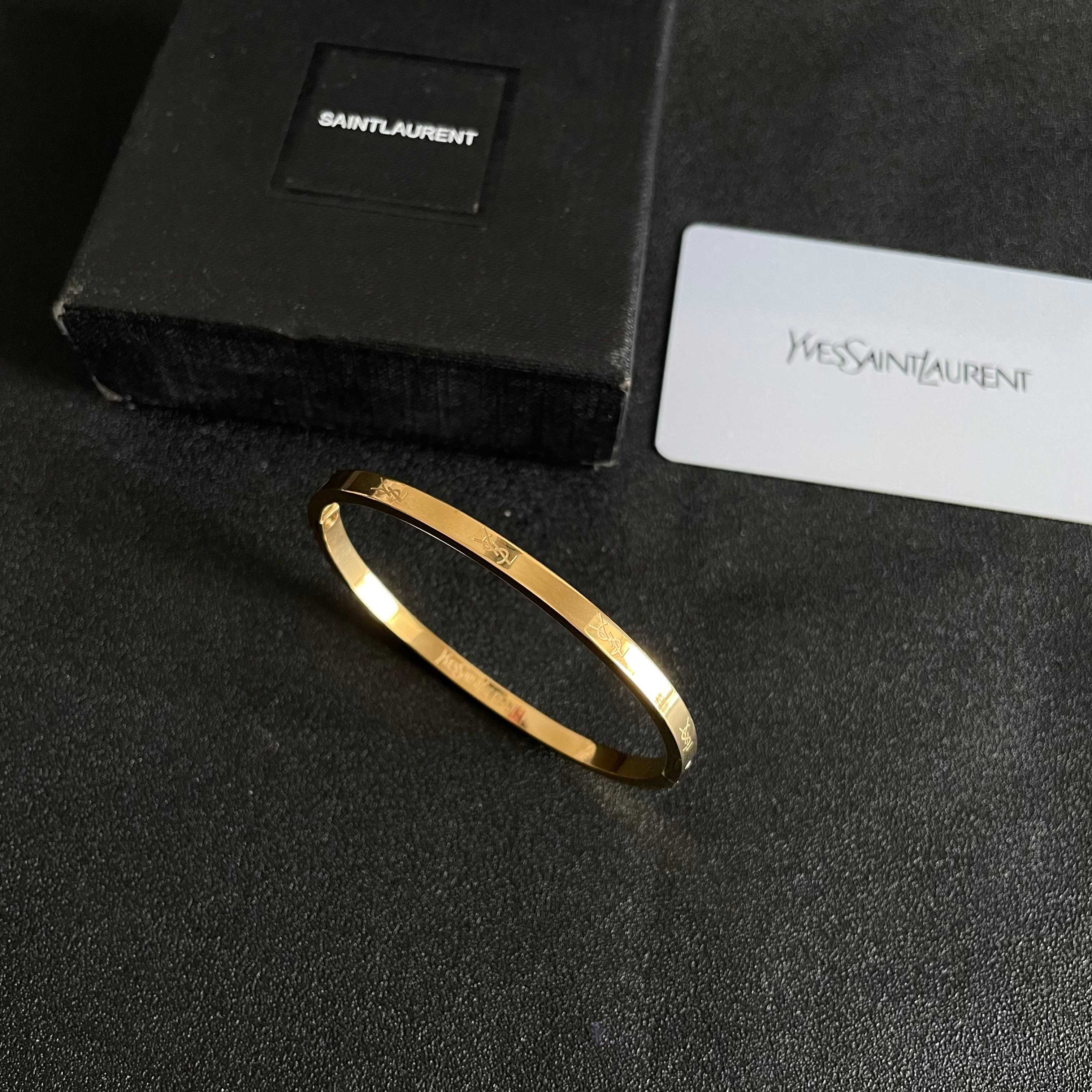 Saint Laurent Cassandre Logo Engraved Hinged Bangle bracelet 18K gold tone metal no accent stones 17cm inner circumference