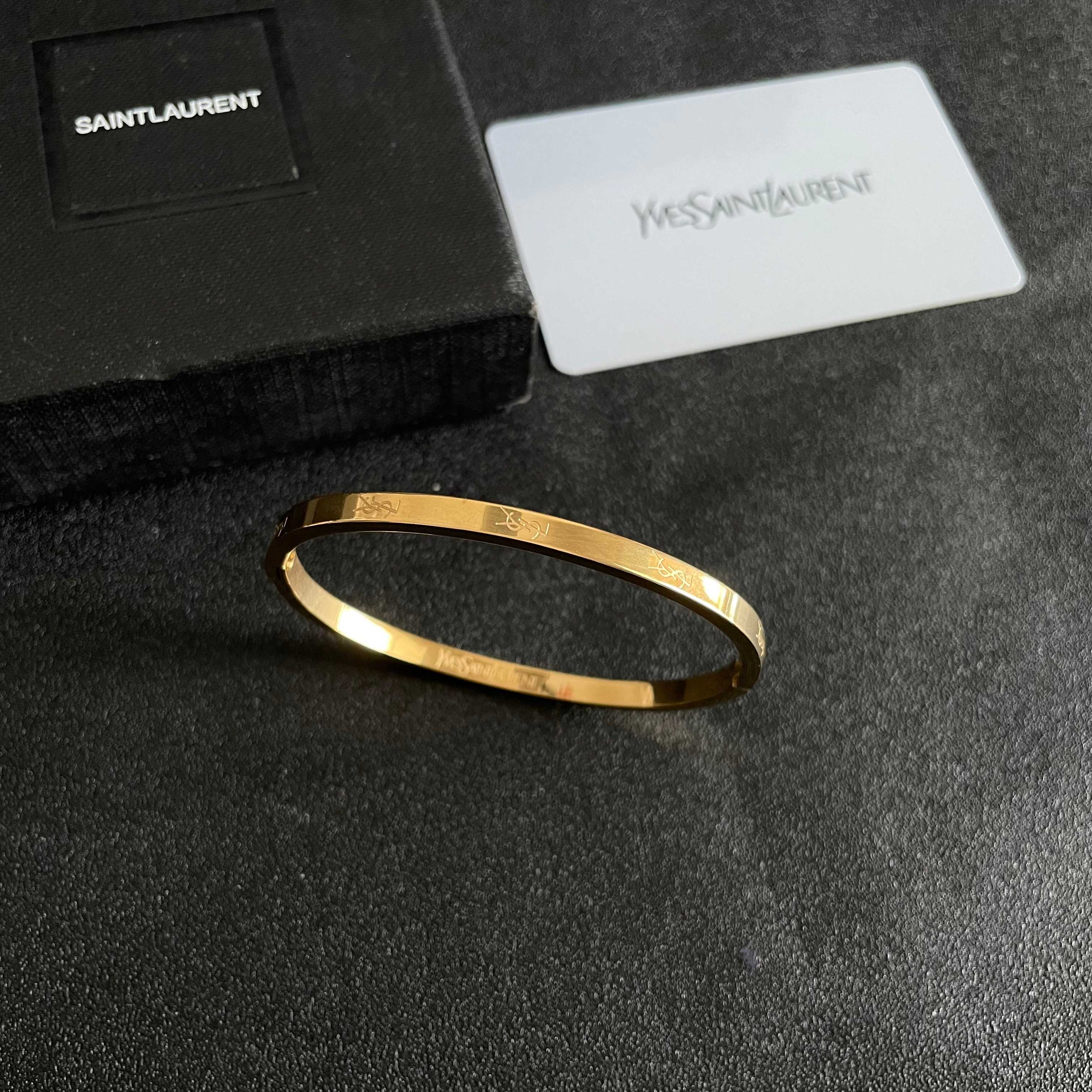 Saint Laurent Cassandre Logo Engraved Hinged Bangle bracelet 18K gold tone metal no accent stones 17cm inner circumference