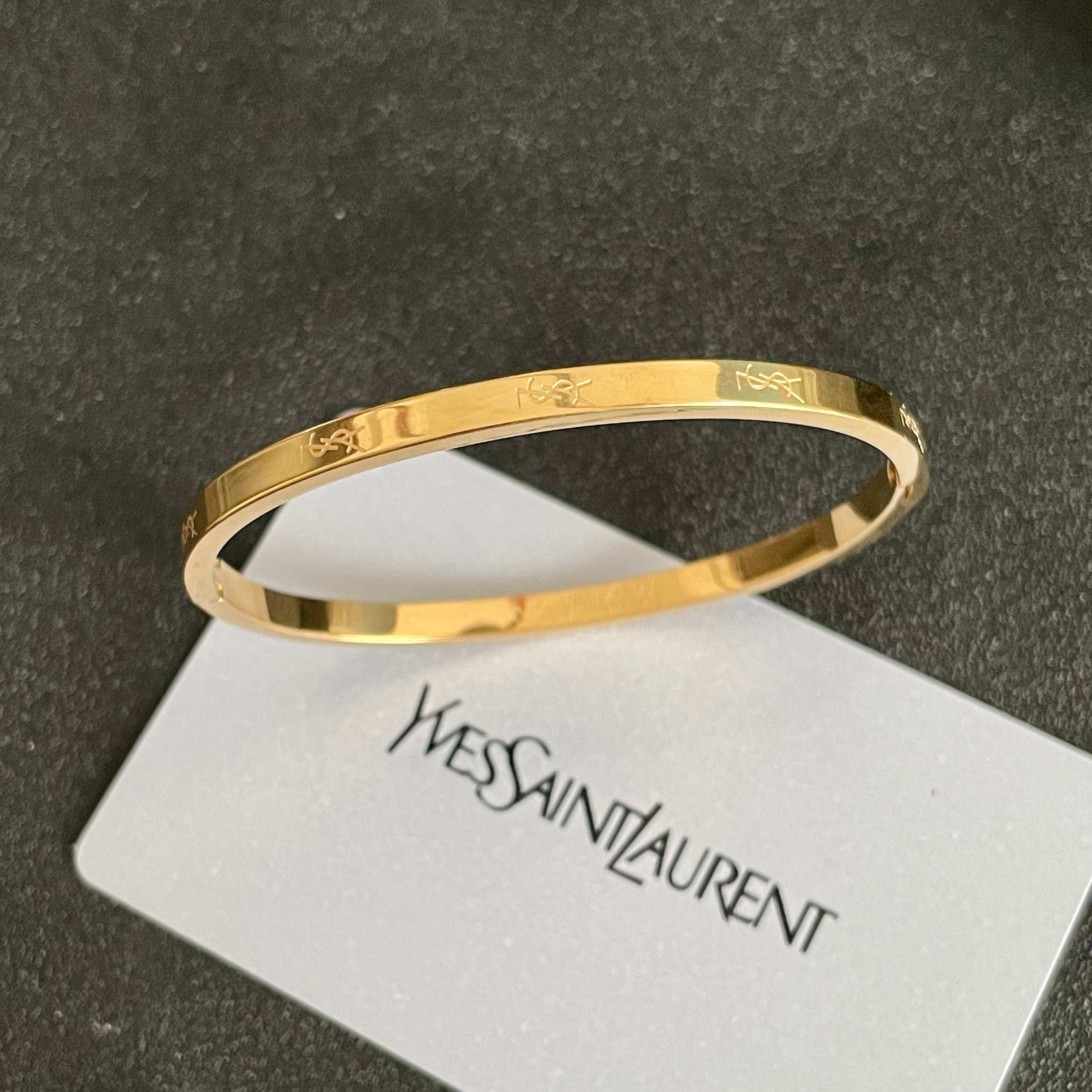 Saint Laurent Cassandre Logo Engraved Hinged Bangle bracelet 18K gold tone metal no accent stones 17cm inner circumference