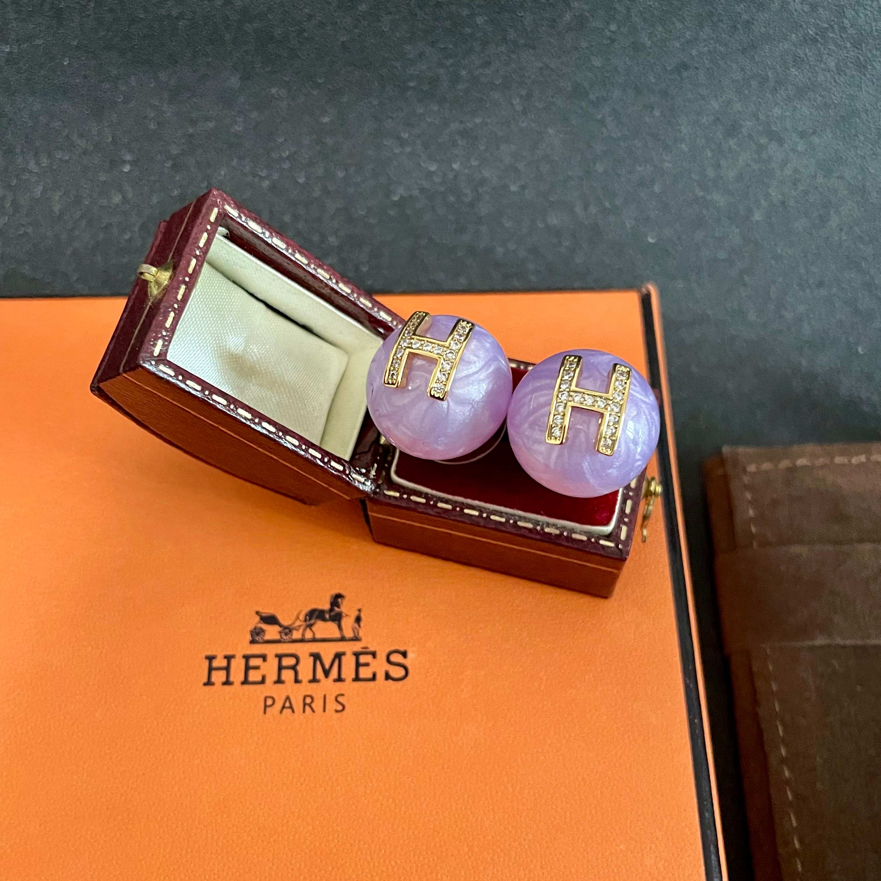 Orecchini Hermes H Logo Orecchini base in resina viola lavanda con logo H in metallo color oro incastonato con cristalli trasparenti diametro 1 2 cm