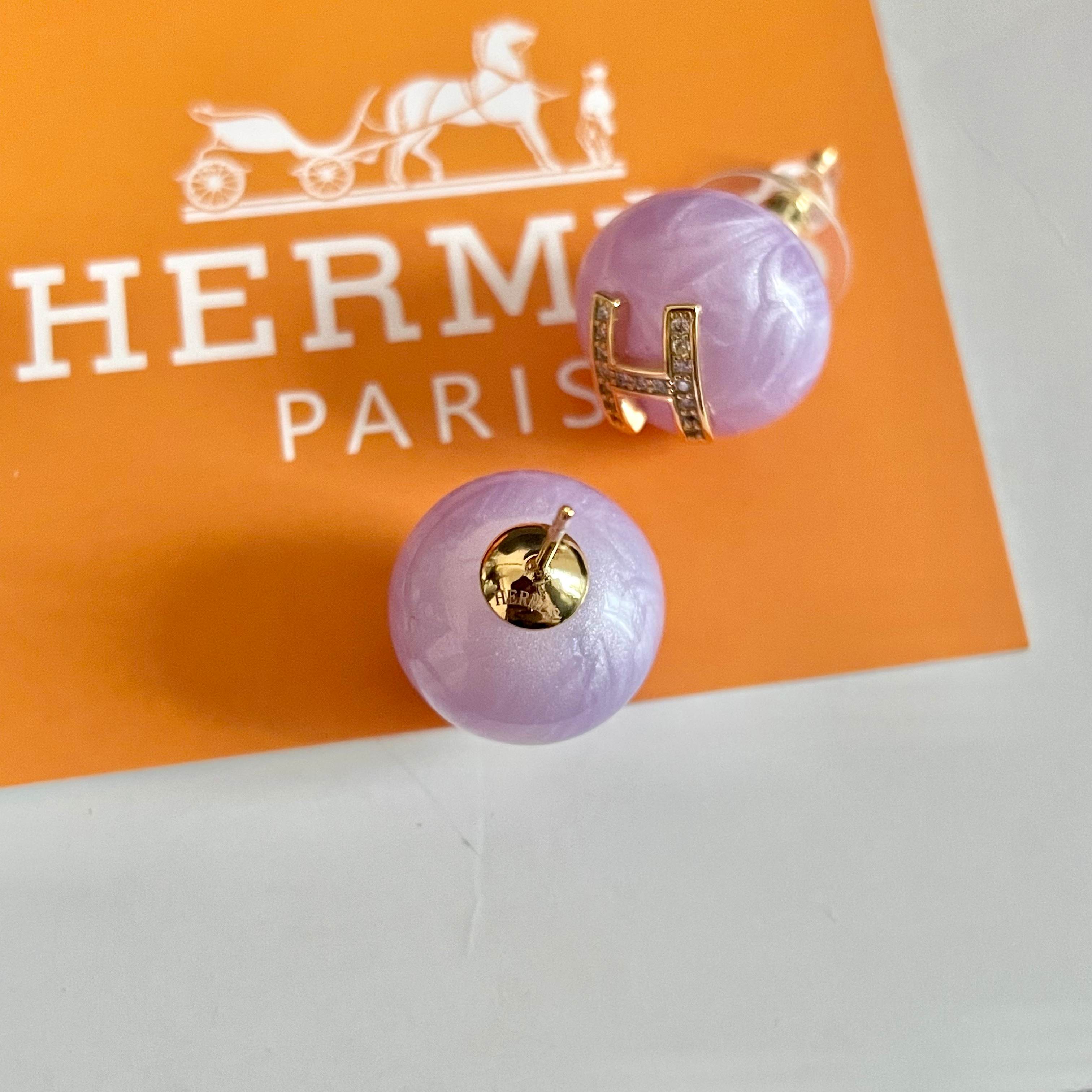 Orecchini Hermes H Logo Orecchini base in resina viola lavanda con logo H in metallo color oro incastonato con cristalli trasparenti diametro 1 2 cm