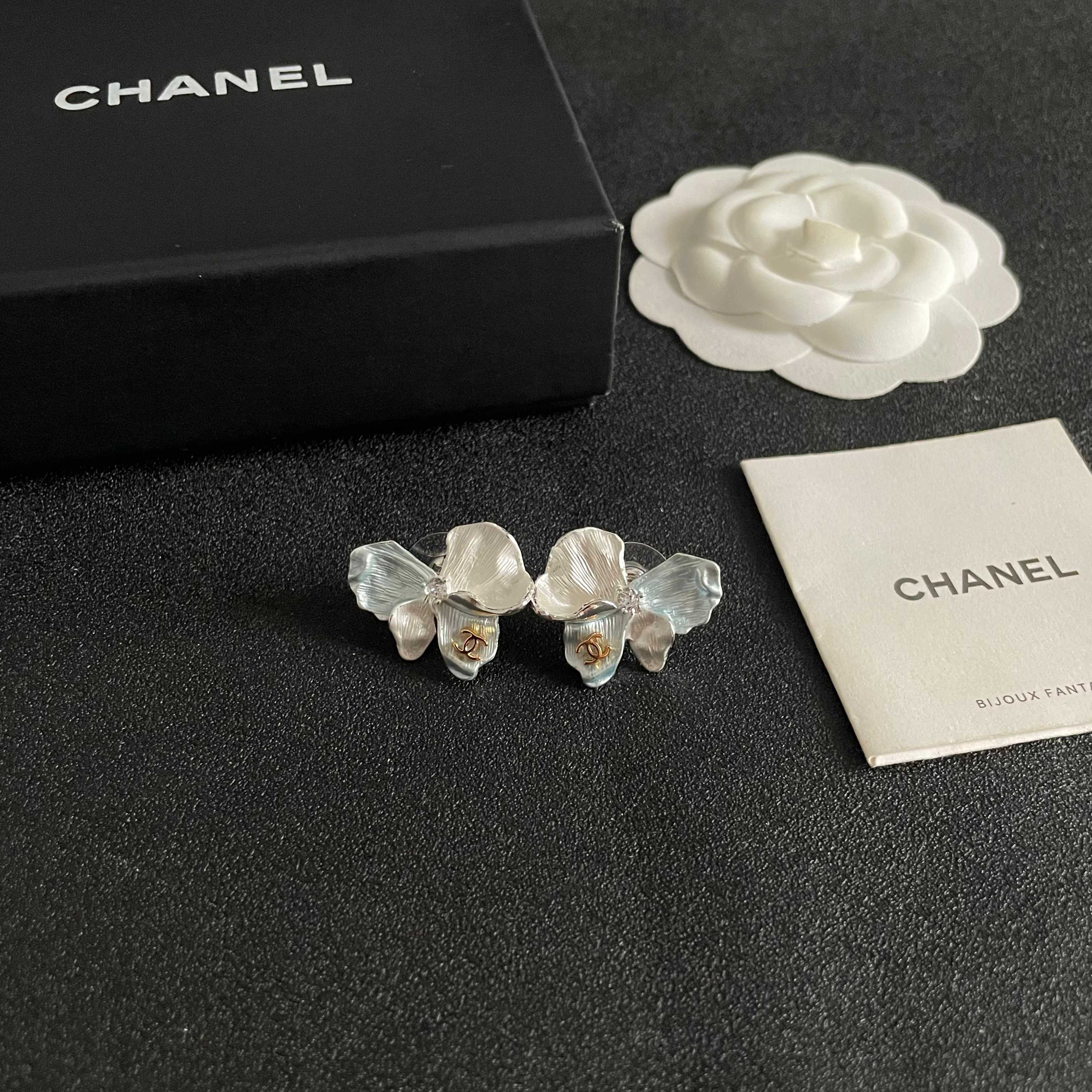 Chanel CC Logo Iridescent Flower Stud Earrings earrings Silver-toned metal with iridescent pearlescent white pale blue pale yellow pale purple or pale peach enamel petals gold-tone interlocking CC logo clear crystal accent One Size 2cm width per earring