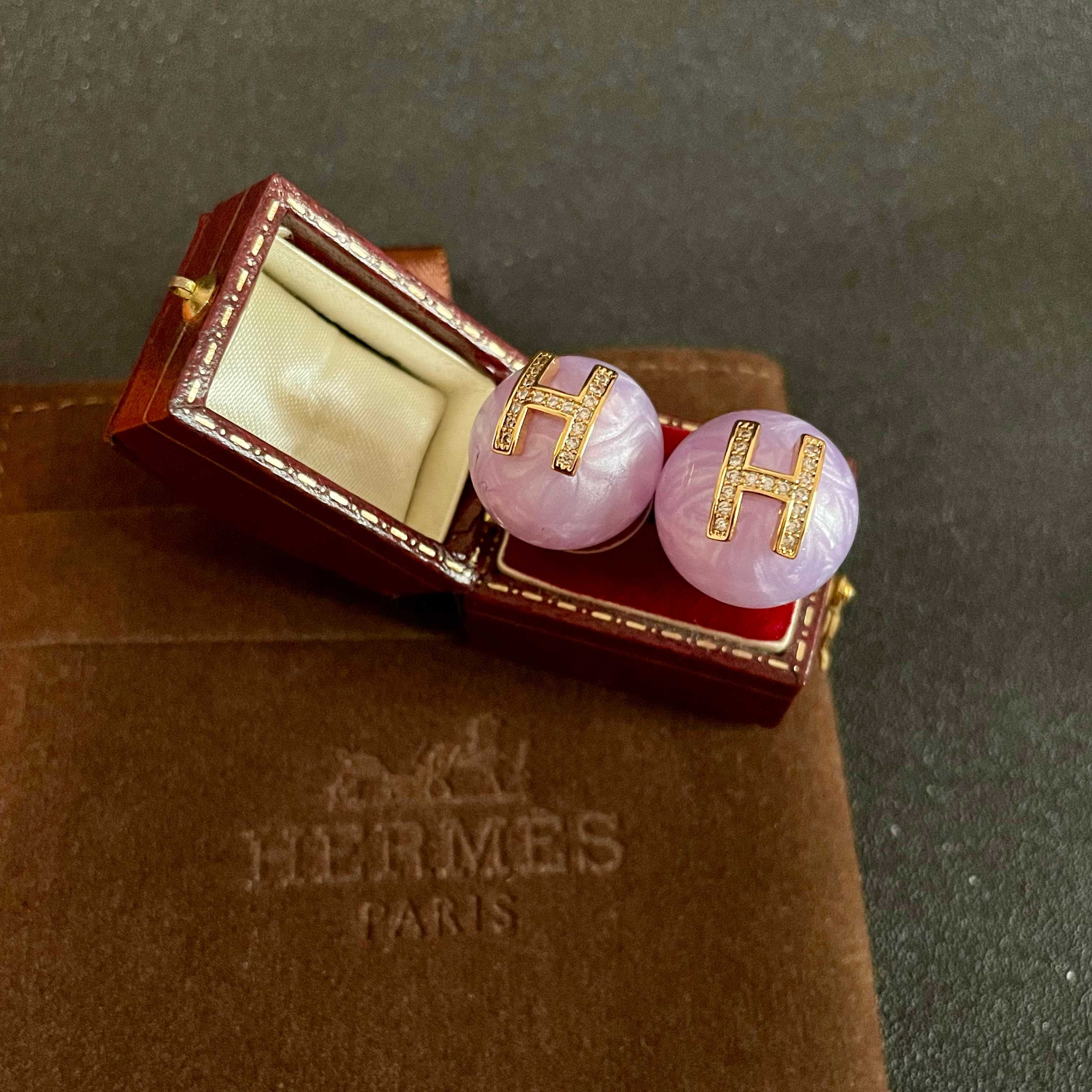 Orecchini Hermes H Logo Orecchini base in resina viola lavanda con logo H in metallo color oro incastonato con cristalli trasparenti diametro 1 2 cm