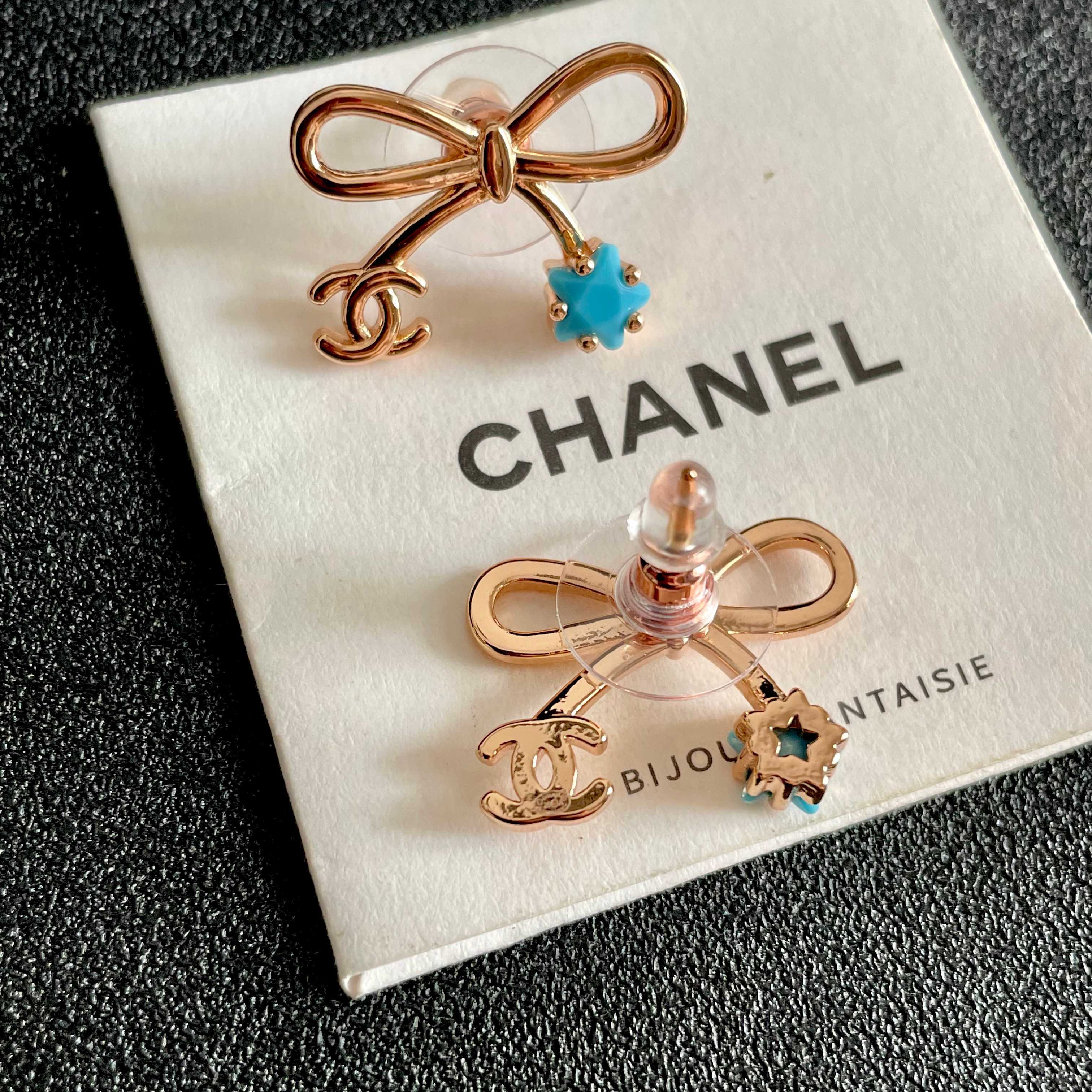 Chanel CC Bow Star Charm Stud Earrings earrings Rose gold light gold tone metal with clear crystal or turquoise blue star accents One Size standard stud earring dimensions approx 1 5cm width