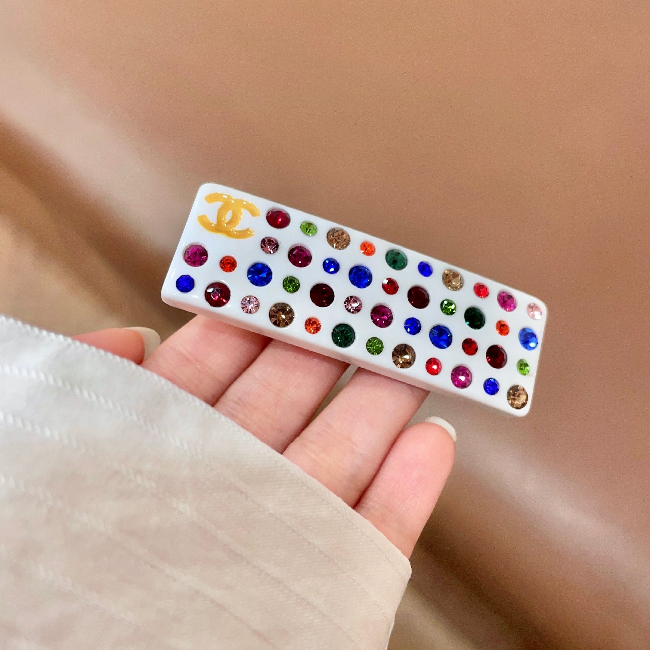 Chanel CC Logo Multicolor Crystal Resin Hair Barrette brooch White resin base with gold-tone interlocking CC logo multicolor faceted crystals in red blue green pink orange champagne and light pink hues 8cm length