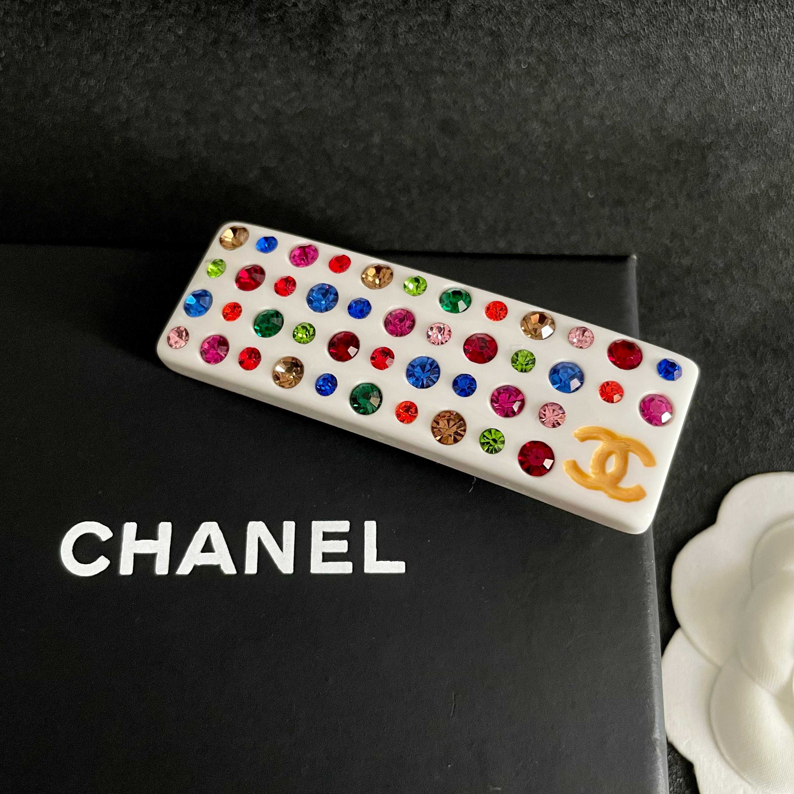 Chanel CC Logo Multicolor Crystal Resin Hair Barrette brooch White resin base with gold-tone interlocking CC logo multicolor faceted crystals in red blue green pink orange champagne and light pink hues 8cm length